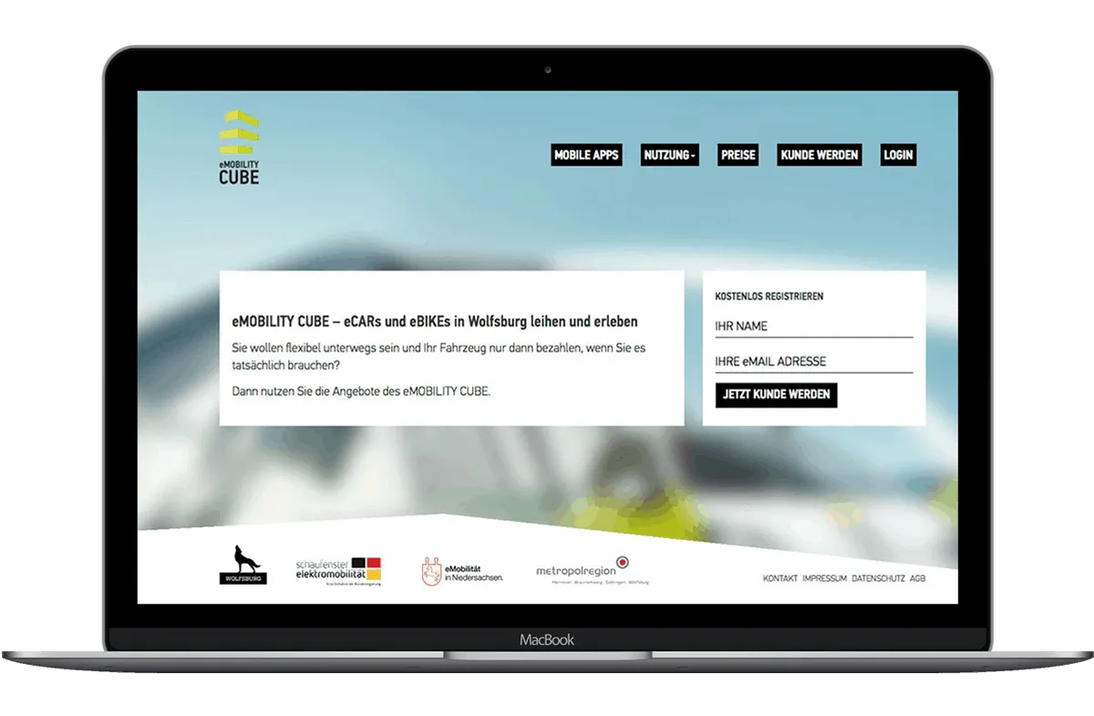 Notebook mit der eMobility-Cube-Website: eCars und eBikes in Wolfsburg leihen, daneben ein Registrierungsfeld