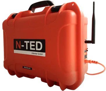 Oranger Transportkoffer mit N-TED-Beschriftung, Antenne und angeschlossenem Kabel
