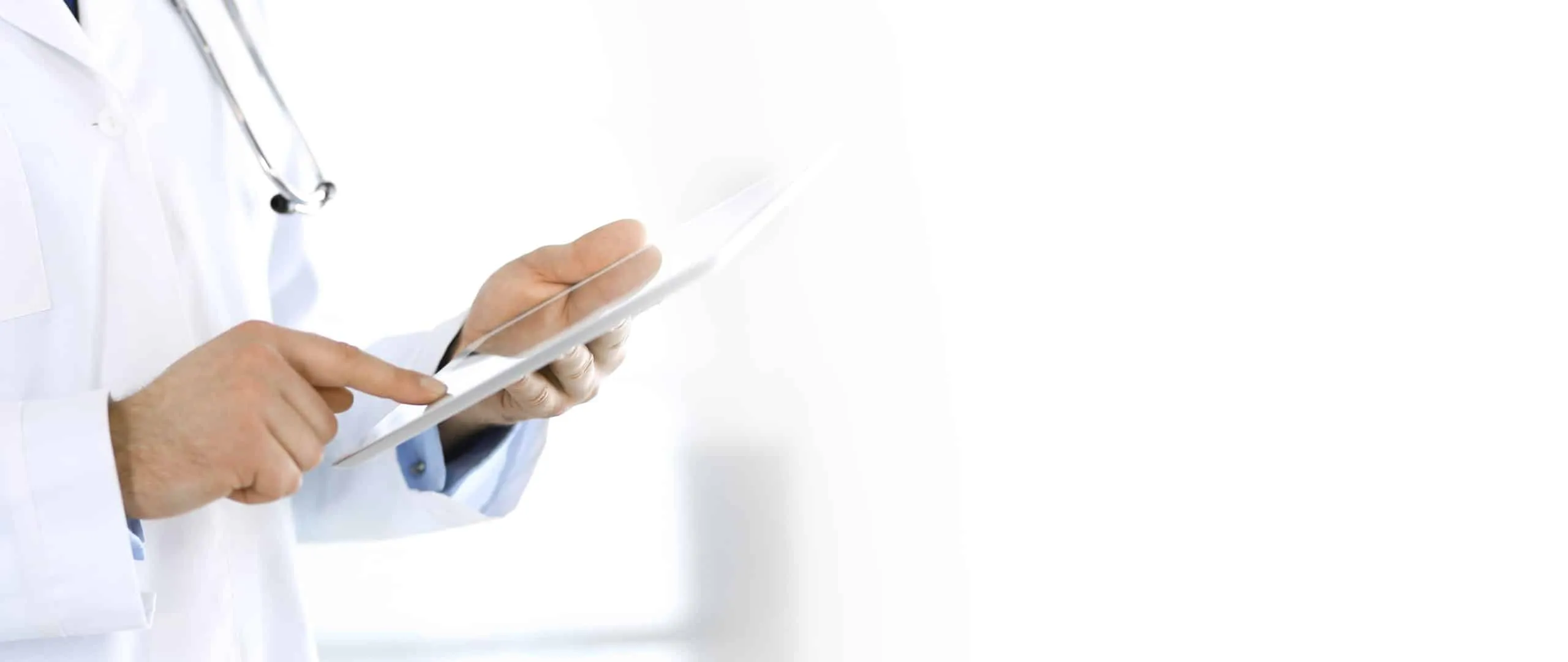 A doctor in a white coat operating a tablet, close-up of the hands